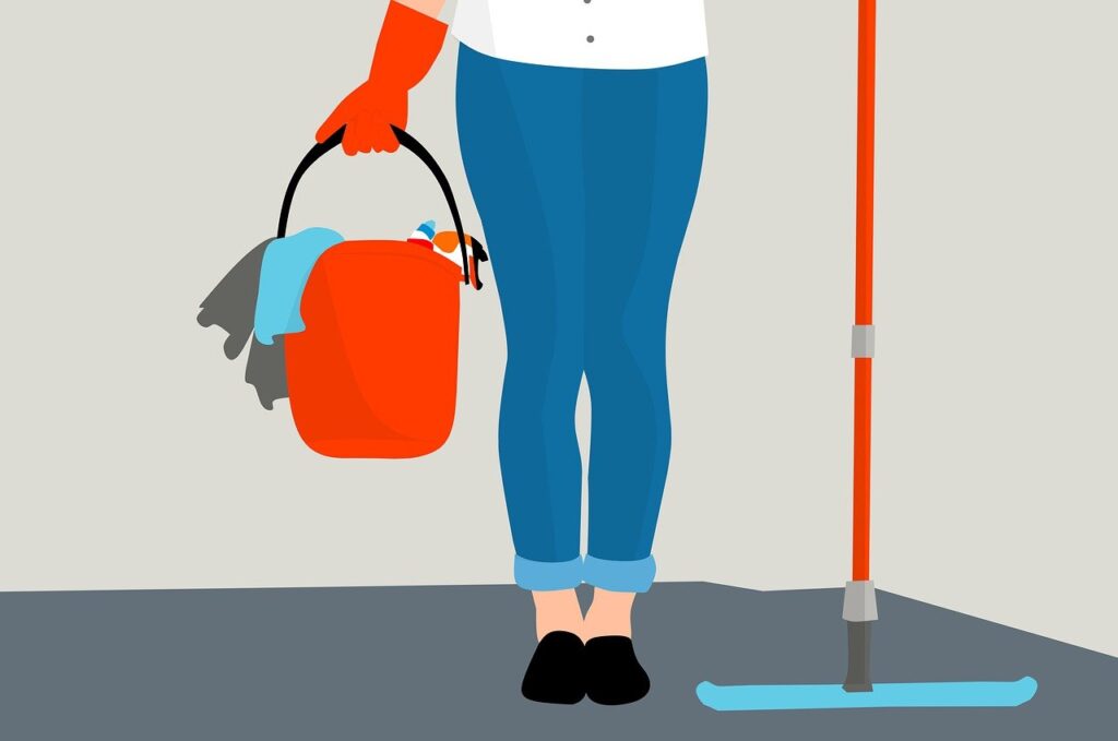 A woman in a blue shirt and red gloves holds a bucket and mop, ready to clean.