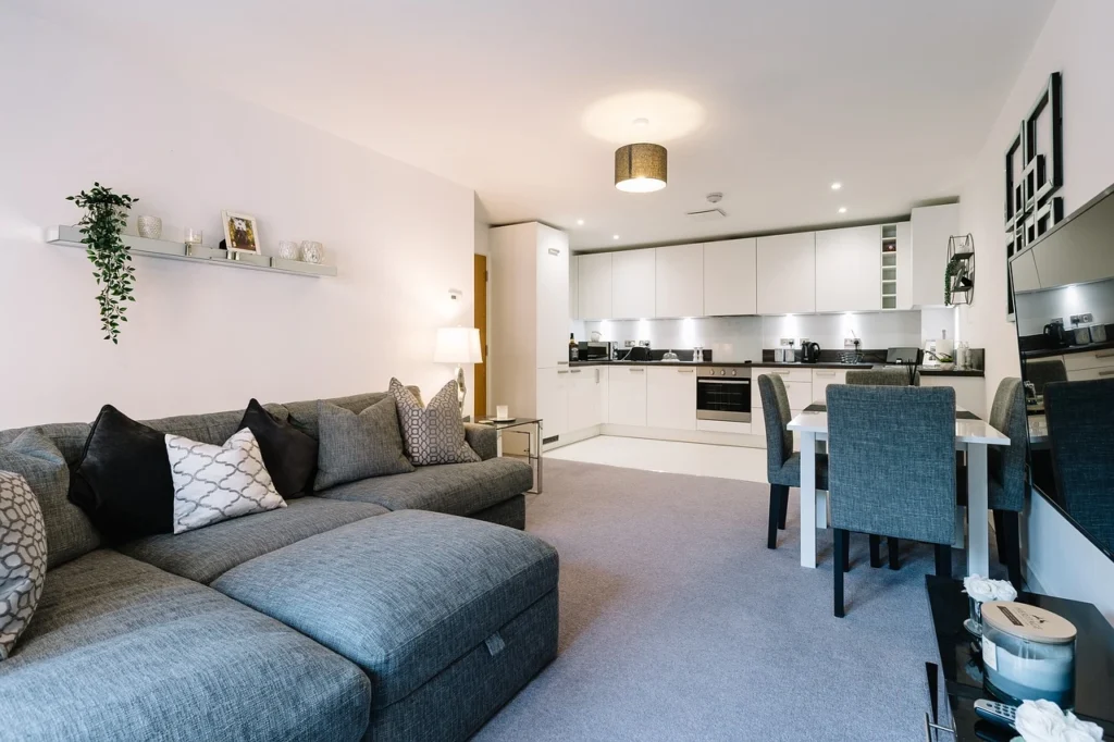 A contemporary living room featuring a stylish couch, a table, and chairs arranged for comfort and socializing.