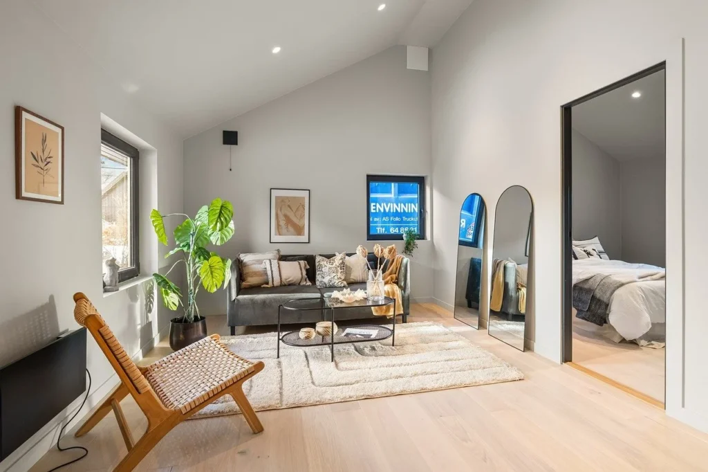 A contemporary apartment featuring a bed, a couch, and a large window allowing natural light to enter