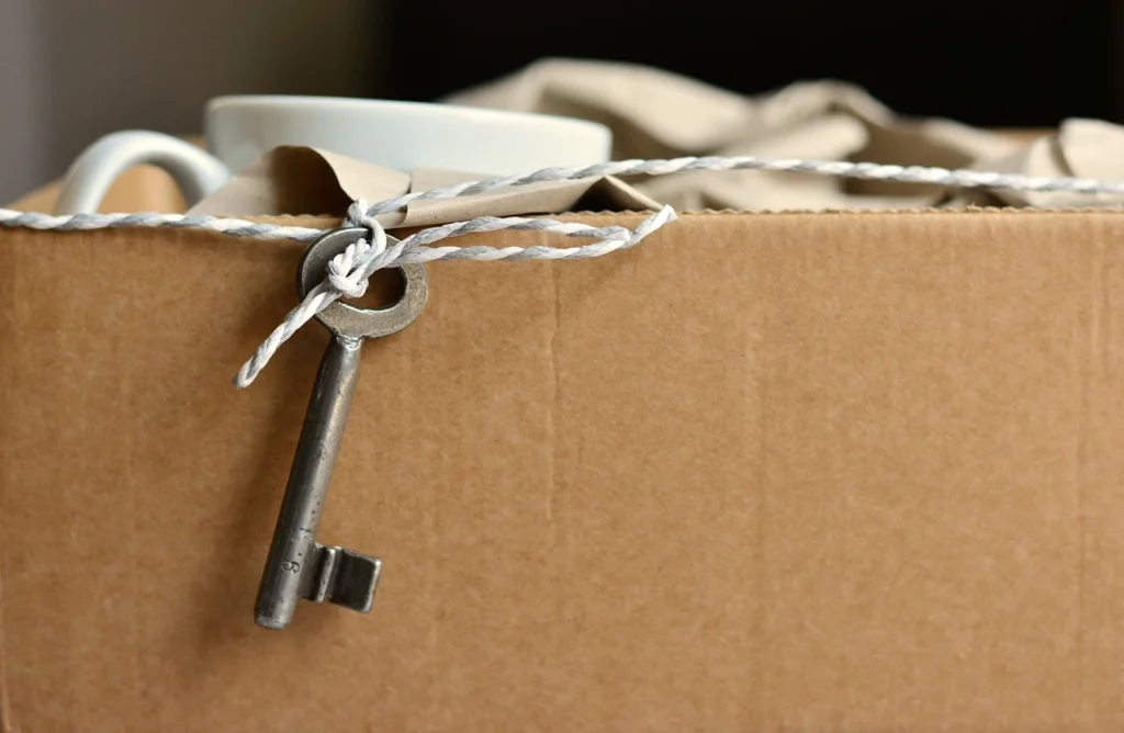 A key and a cup are placed inside a box, which is secured with a rope.