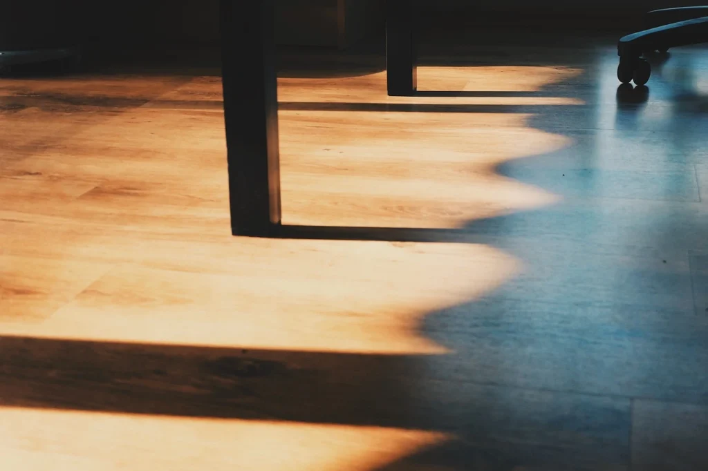 A wooden floor featuring a chair and a table, creating a cozy and inviting interior space.