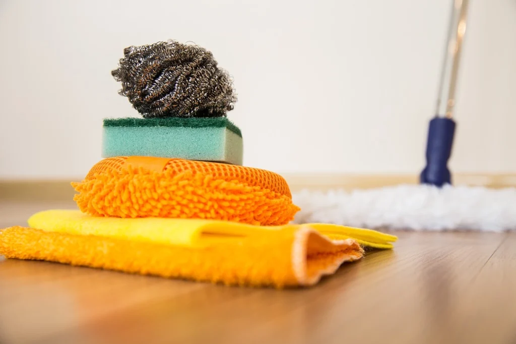 Cleaning supplies arranged neatly on a wooden floor, showcasing various tools and products that reflect cleaning trends for effective home cleaning.