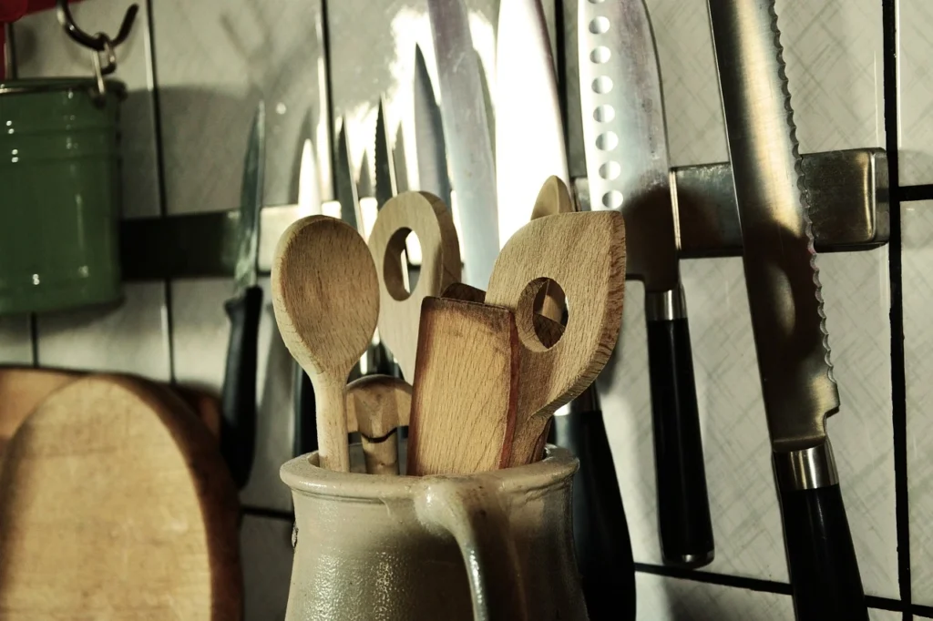 A collection of knives and utensils, common kitchen appliances, arranged neatly in a cup, showcasing their varied shapes and sizes.
